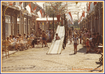 862132 Afbeelding van deelnemers aan het straatfeest in de Kovelaarstraat te Utrecht, met centraal de 'rutschbaan'.
